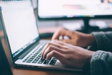 Person's hands typing on computer