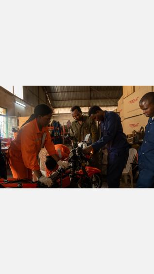 Women and men working on a motorcycle