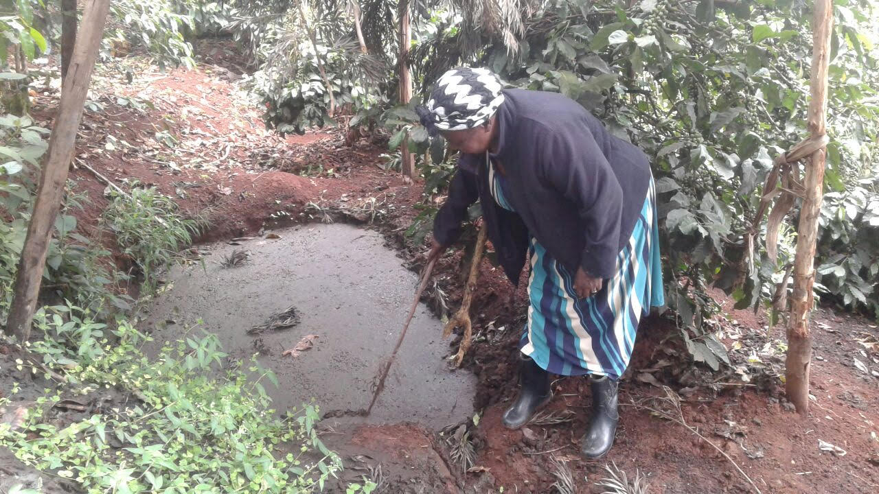 Dionesia Ireri stirs the cow dung mixture that she transforms into biogas with the help of a biodigester. Credit: SNV.